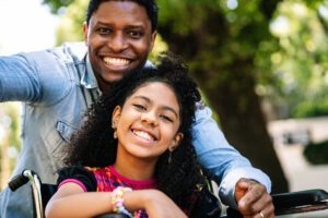 Girl in wheelchair with man 